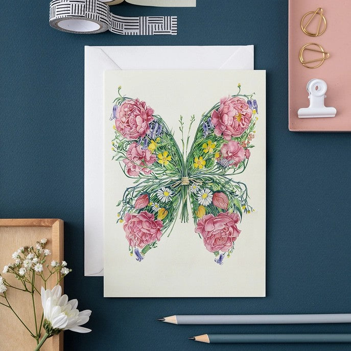Floral butterfly card on a desk with stationery.