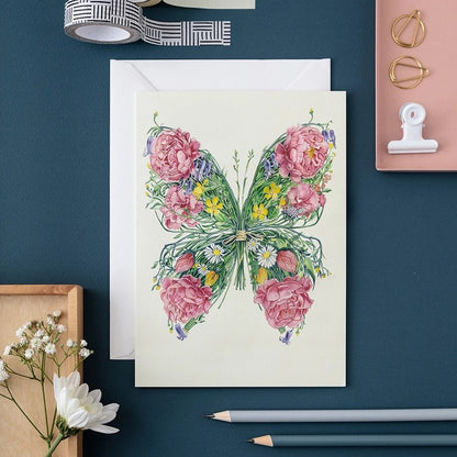 Floral butterfly card on a desk with stationery.