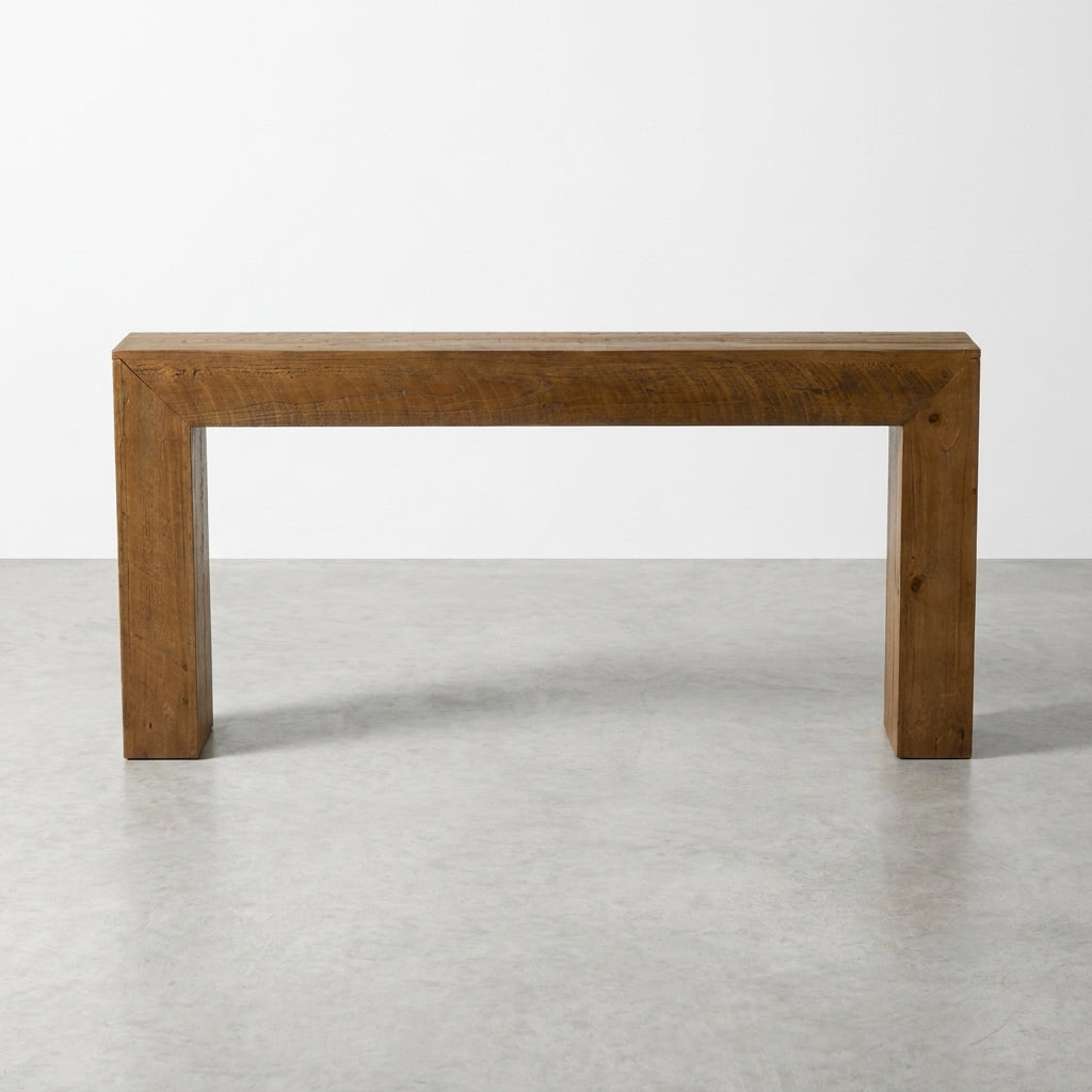 Minimalist wooden console table on a gray floor.
