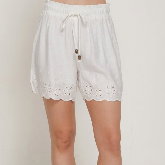 White shorts with floral embroidery and drawstring.