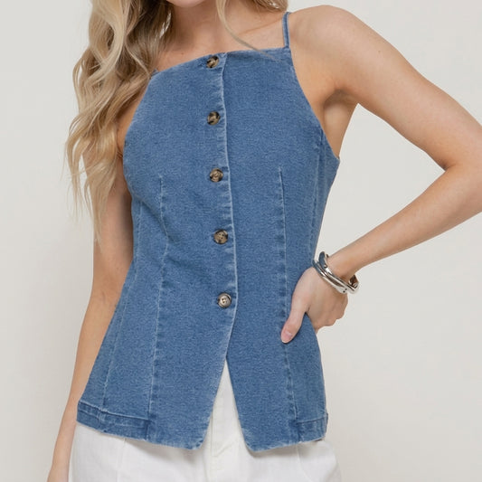 Woman in a blue button-up denim top with white pants.