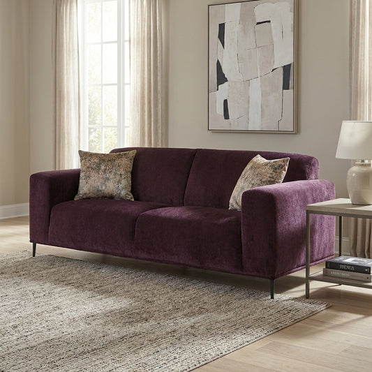Plush purple sofa with two floral cushions and sleek legs.