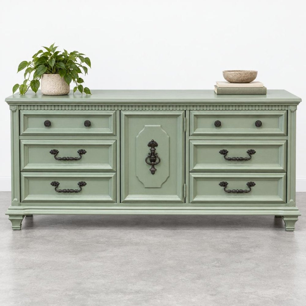 Mint green dresser with a potted plant and a decorative bowl on top.