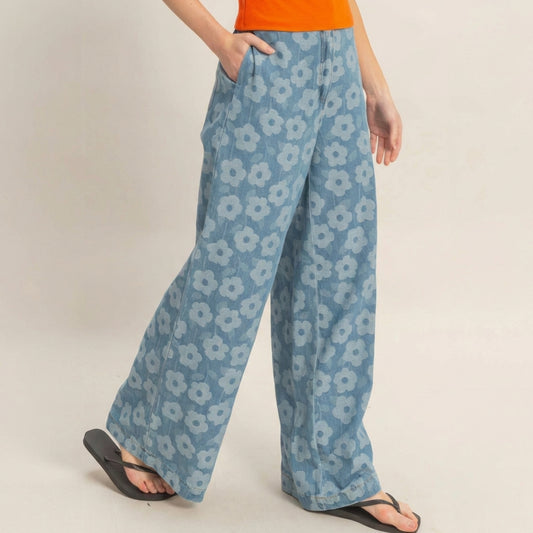 Person in floral blue pants, orange top, and black sandals.