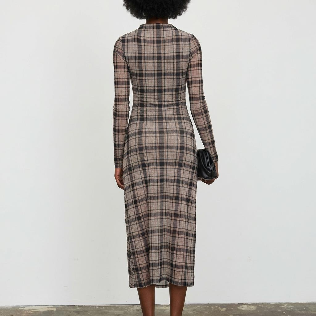 Person in a plaid dress holding a black bag, viewed from the back.