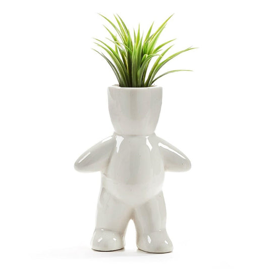 White human-shaped planter with green plant on top.