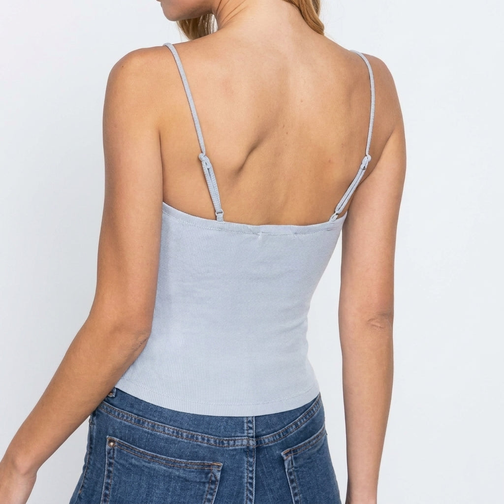 Person in a light blue strap top and jeans, back view.