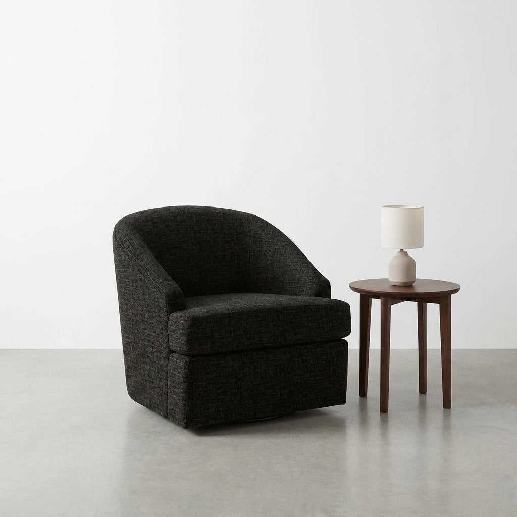 Cozy black chair and lamp on a wooden table in a minimalist room.