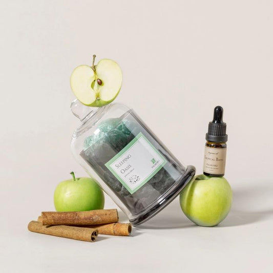 Apples, cinnamon, sleeping salts, and an essential oil bottle on display.