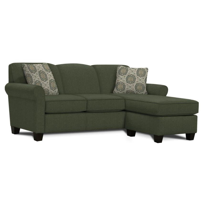 Green sectional sofa with patterned pillows.