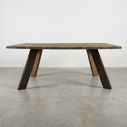 Wooden table with slanted legs on a gray floor.
