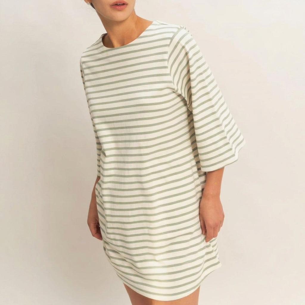 Person wearing a striped, knee-length dress against a plain background.