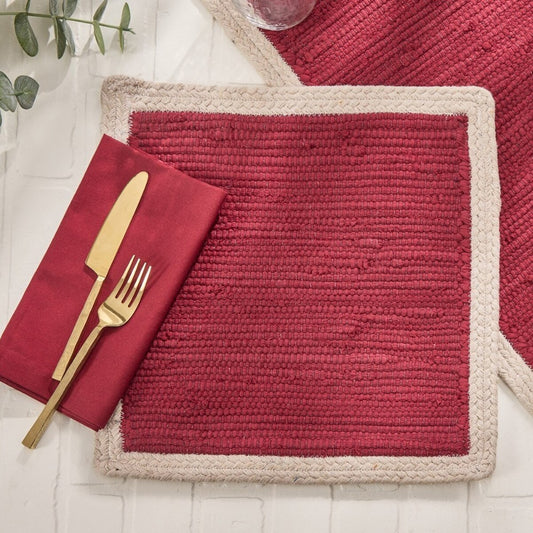 Red woven placemat with gold cutlery and red napkin.