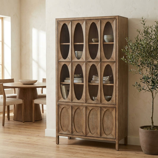Wooden cabinet with oval glass panels beside round dining table.