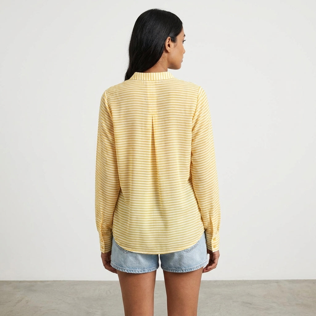 Woman in yellow striped shirt and denim shorts, facing away.
