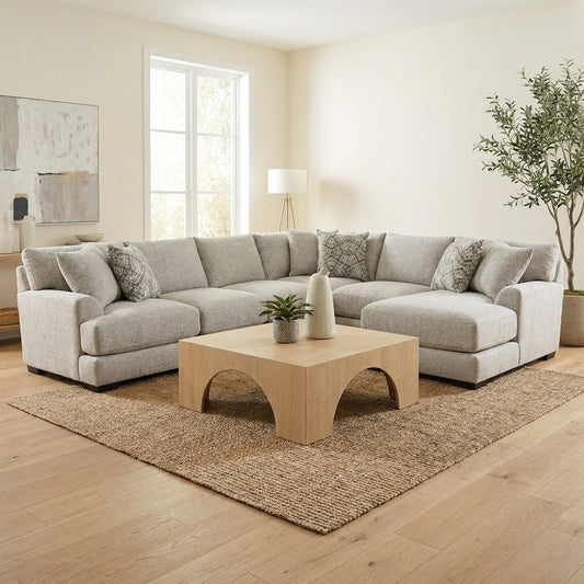 Modern living room with gray sectional sofa and wooden coffee table.