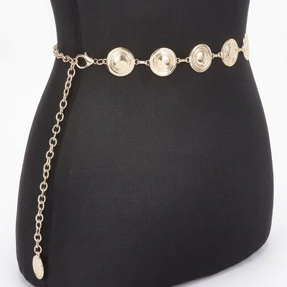 Gold chain belt with round discs displayed on a black mannequin.