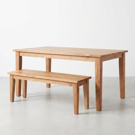 Wooden table with a matching bench in a light, minimalist setting.