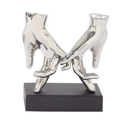 Two metallic hands intertwined, mounted on a black base.