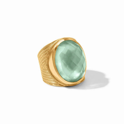 Gold ring with an ornate band and a large faceted pale aqua gemstone.