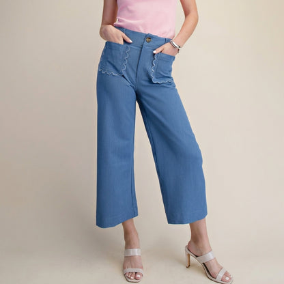 Pink top, blue pants with scalloped pockets, white heels.