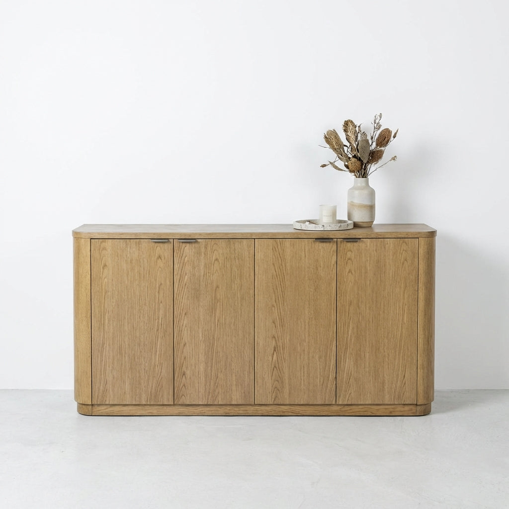 Wooden cabinet with vase and candles on top against a white wall.