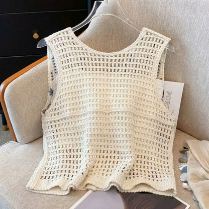 White crochet tank top on a beige armchair with a magazine nearby.