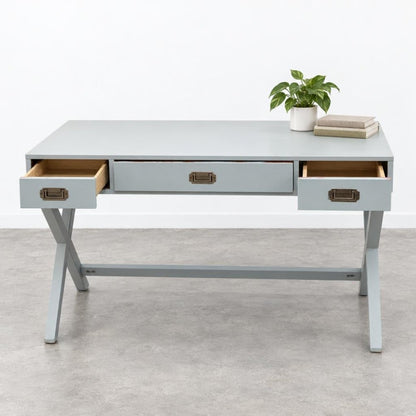 A pale gray desk with open drawers, topped with a potted plant and stacked books.