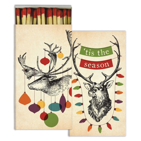 Deer with ornaments, "Tis the Season" banner, boxed matches.