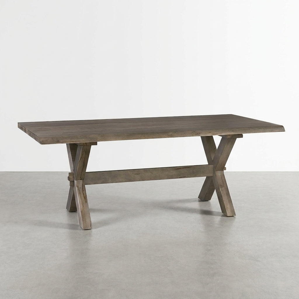 Wooden table with a trestle base on a light gray floor.