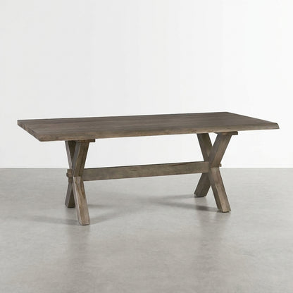 Wooden table with a trestle base on a light gray floor.