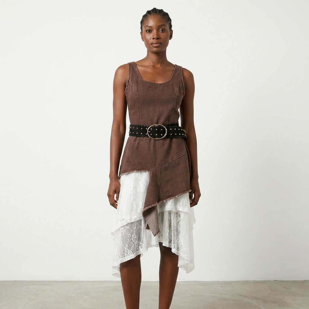Person in brown top and white lace skirt with black belt, standing against a plain background.