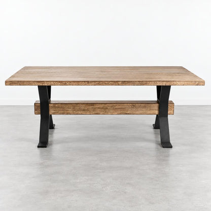 A rustic wooden table with black metal legs stands against a plain white wall.