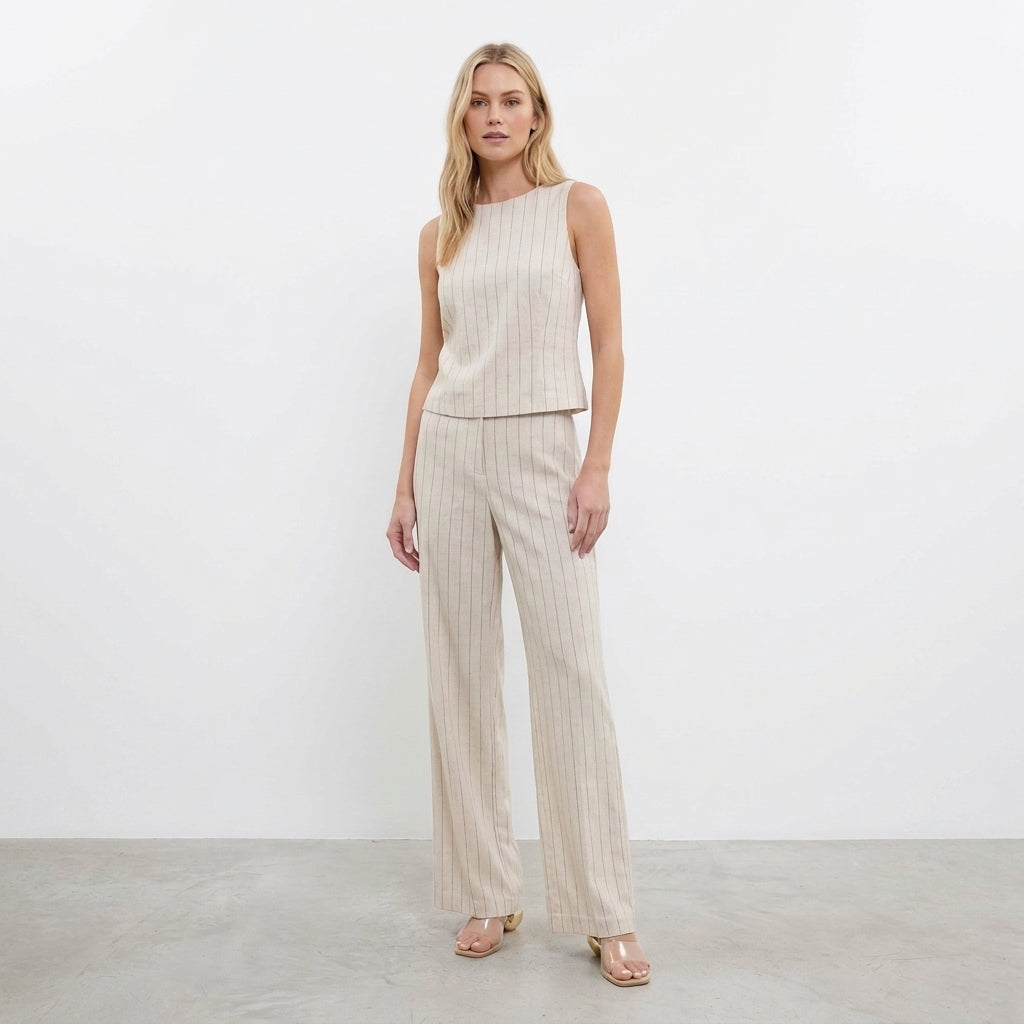 Woman in beige pinstripe pants and sleeveless top.