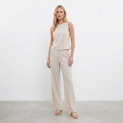 Woman in beige pinstripe pants and sleeveless top.