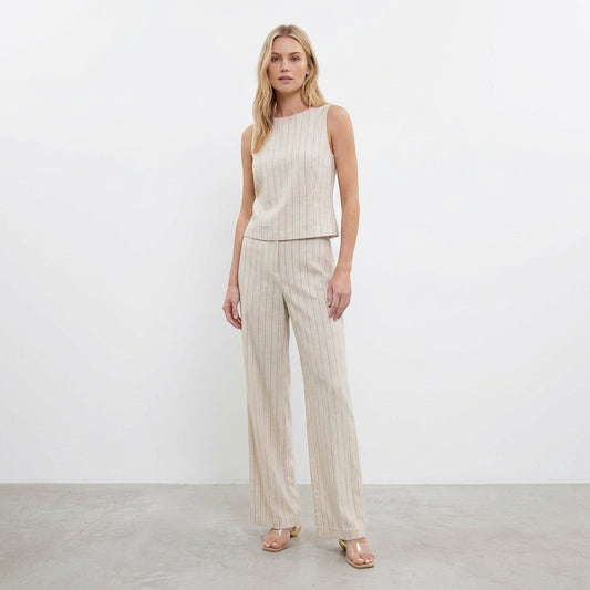 Woman in beige pinstripe pants and sleeveless top.