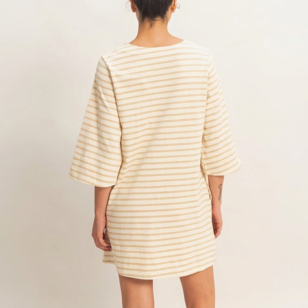 Person in striped shirt dress, seen from the back.
