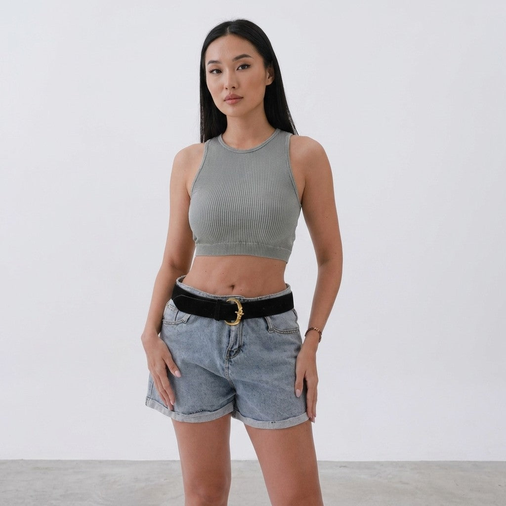 Woman in a crop top and shorts against a white background.