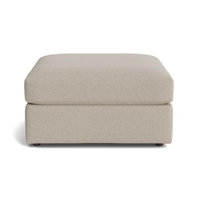 Beige square ottoman with simple, modern design.