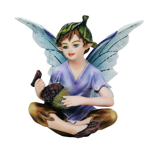 Fairy figurine with blue wings, seated, holding a pinecone.