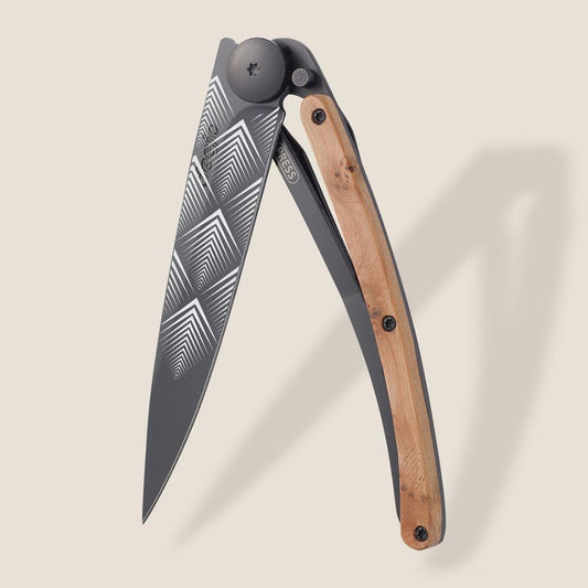 Stylish folding knife with patterned blade and wooden handle.