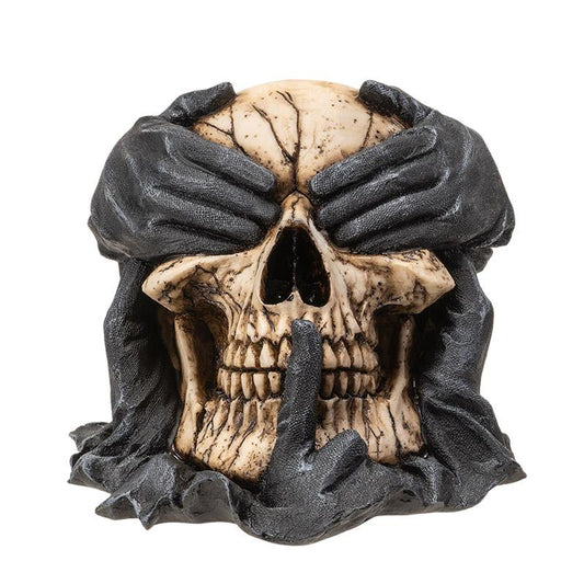 Skull with black hands covering eyes and mouth, shushing gesture.