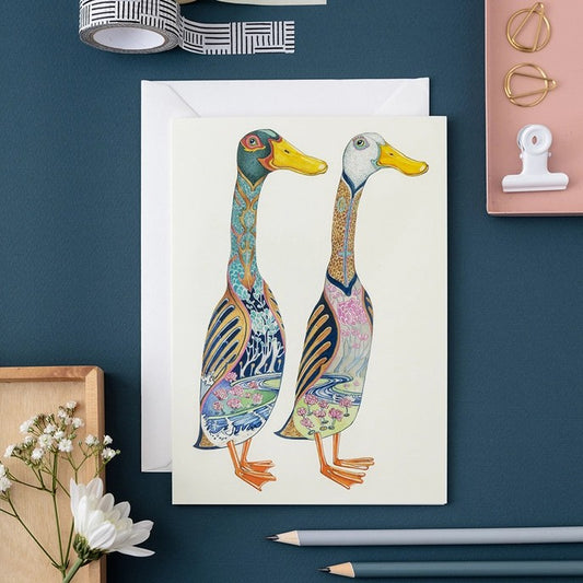 Decorative duck illustration on a card surrounded by stationery items.