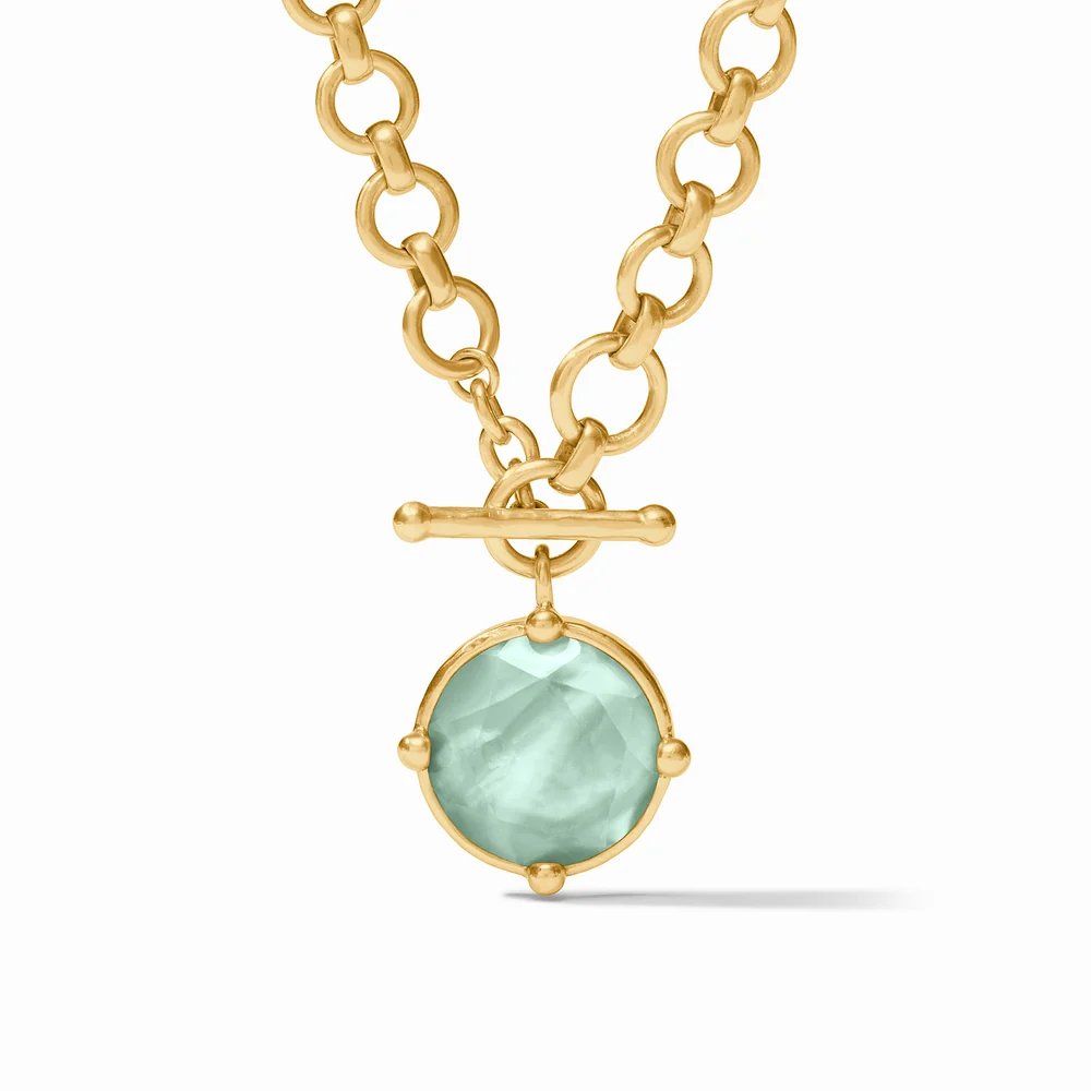 Gold chain necklace with a light blue gemstone pendant.