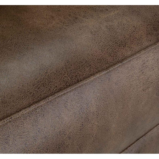 Close-up of brown textured leather with visible seams.