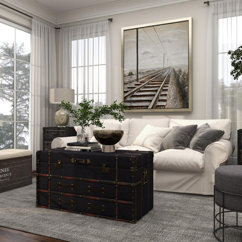 Elegant living room with a trunk table, sofa, and railroad painting.