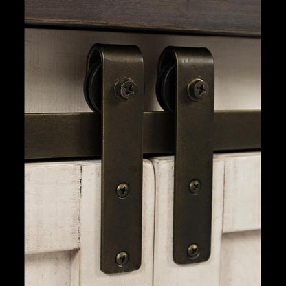 Metal sliding door hardware on a rustic, light wooden door.