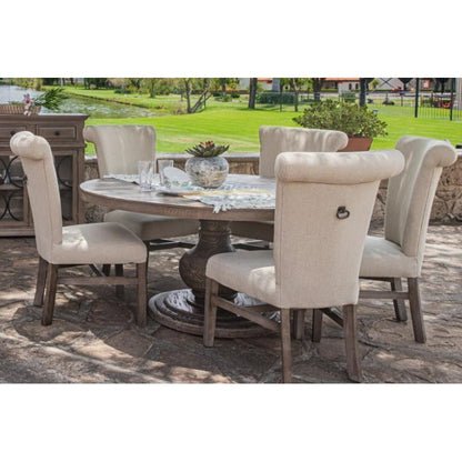 Outdoor dining set on patio, lush greenery in background.