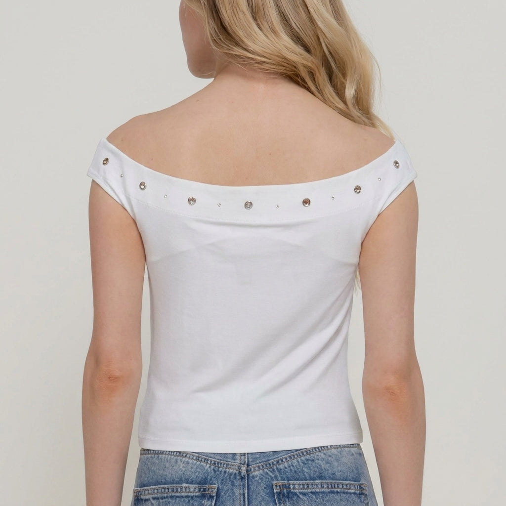 Back view of a person in a white off-shoulder top with rhinestones.