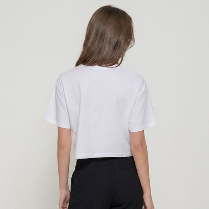 Person in a white cropped t-shirt and dark pants, facing away.
